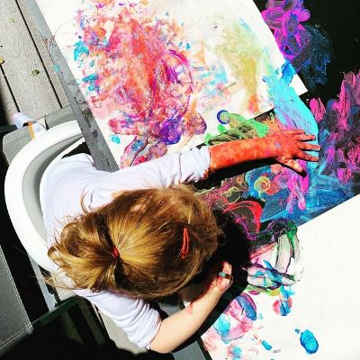 Her hand is all covered in painting.